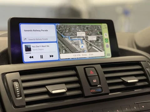 Apple CarPlay navigation and music on a BMW dashboard display